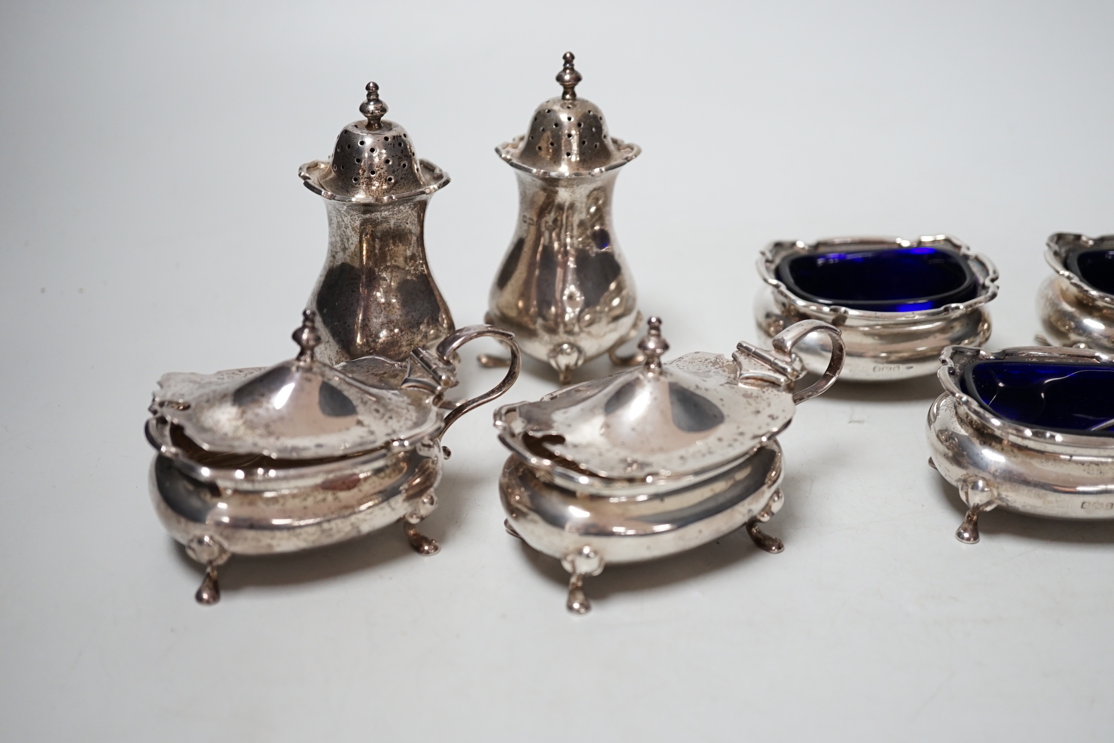 Two four piece silver cruet sets.